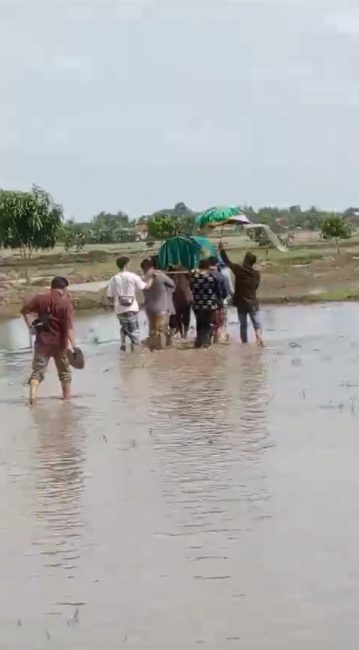 foto: Warga membawa jenazah melewati sawah